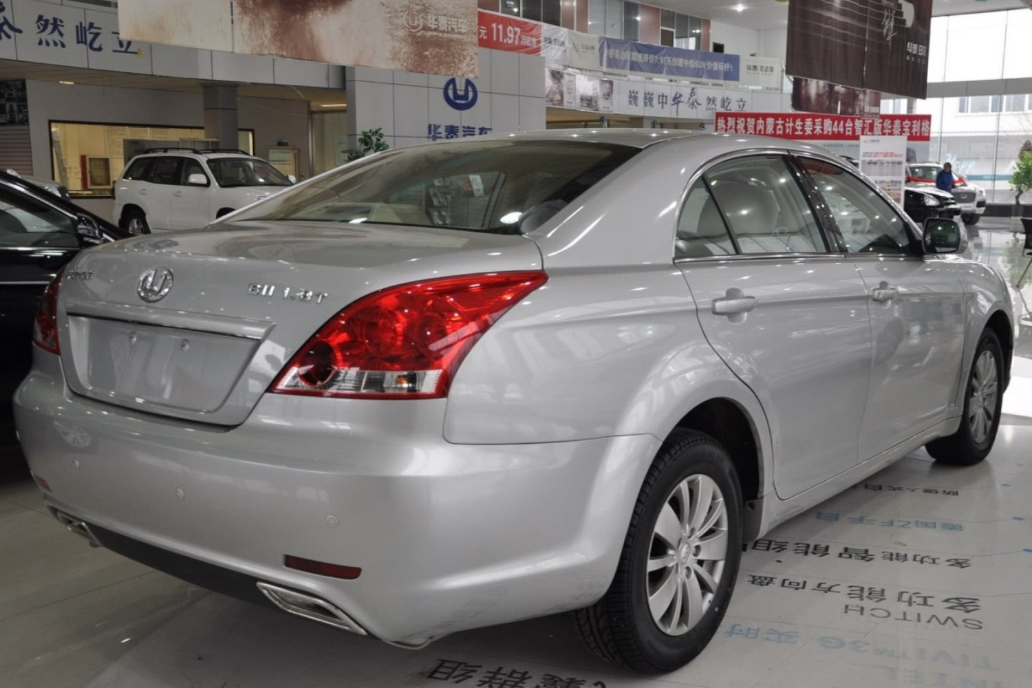 Silver sedan rear view with distinctive taillights and dual exhaust tips