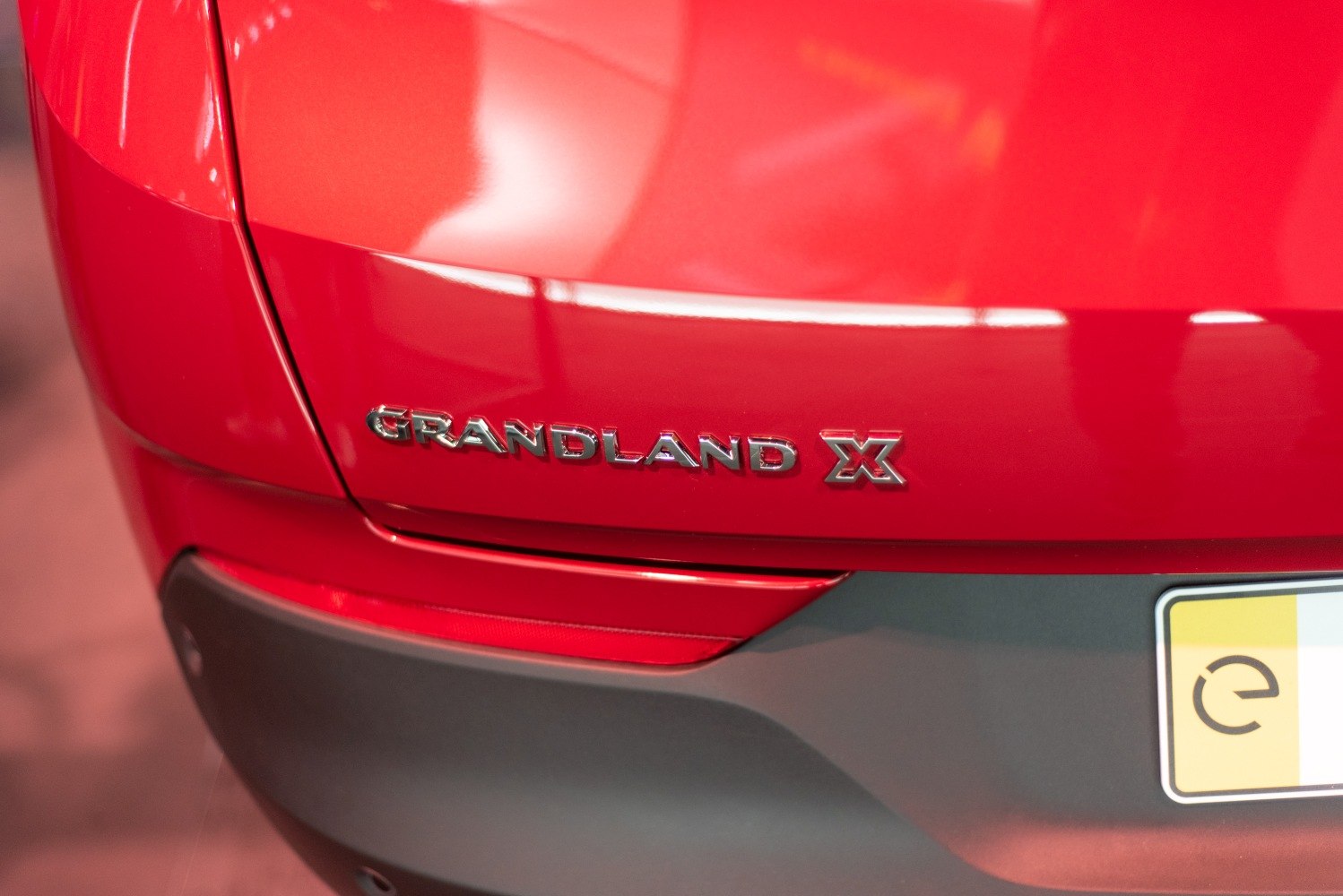 Close-up of rear badge and bumper of a red vehicle