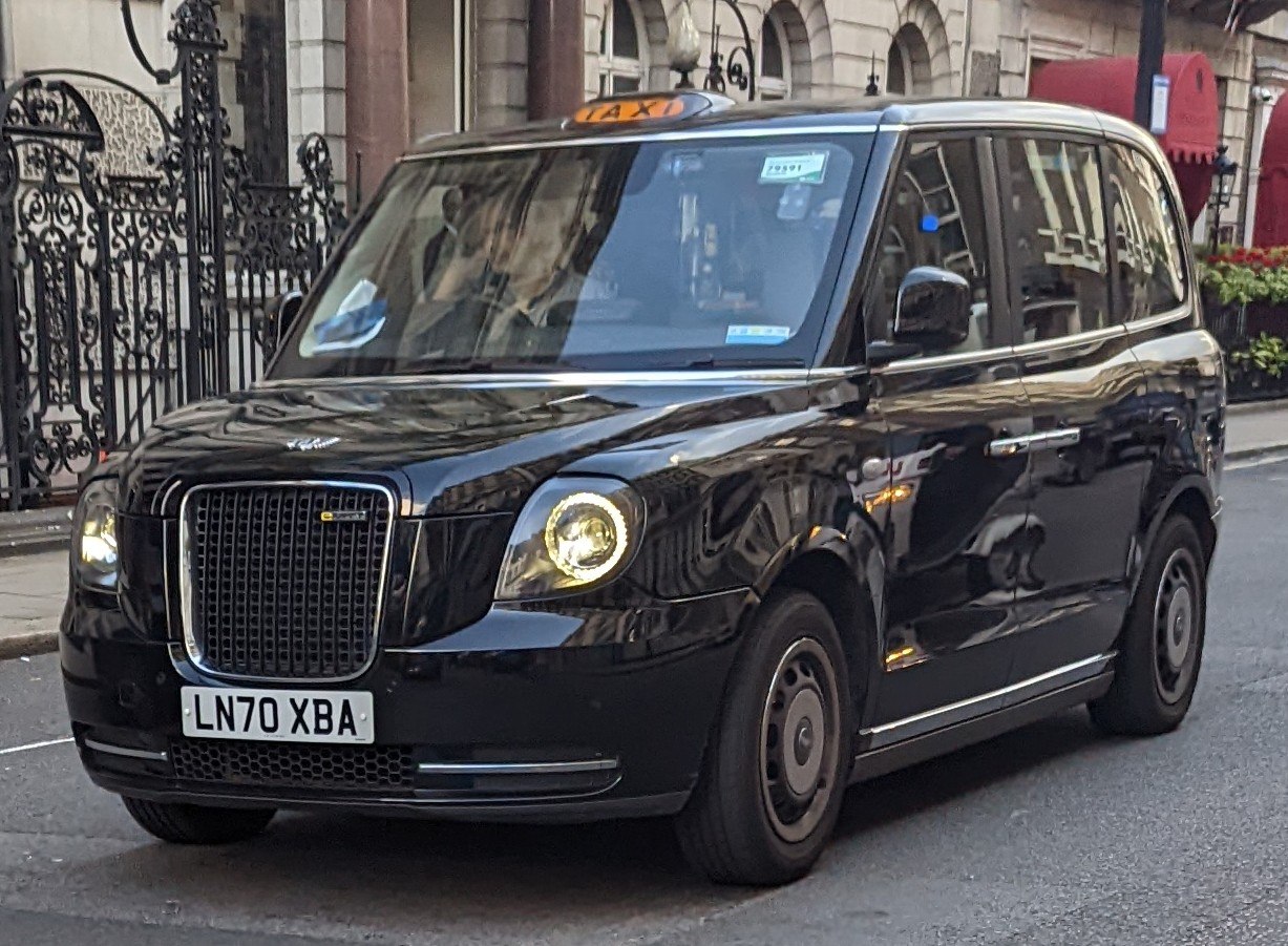Front view of a black taxi with distinctive grille and round headlights.