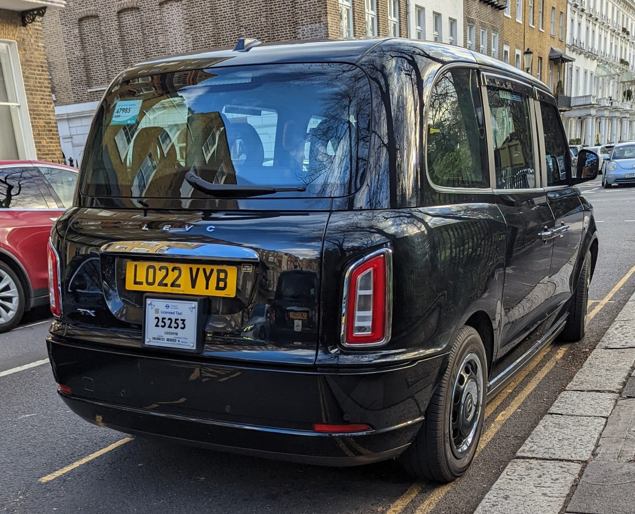 Rear view of a modern electric taxi with distinct rear lights and badge.