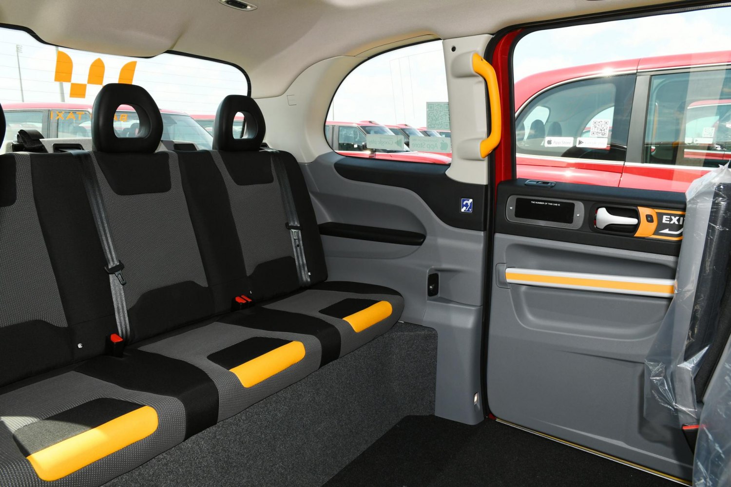 Rear bench seat with yellow highlights and grab handle inside taxi