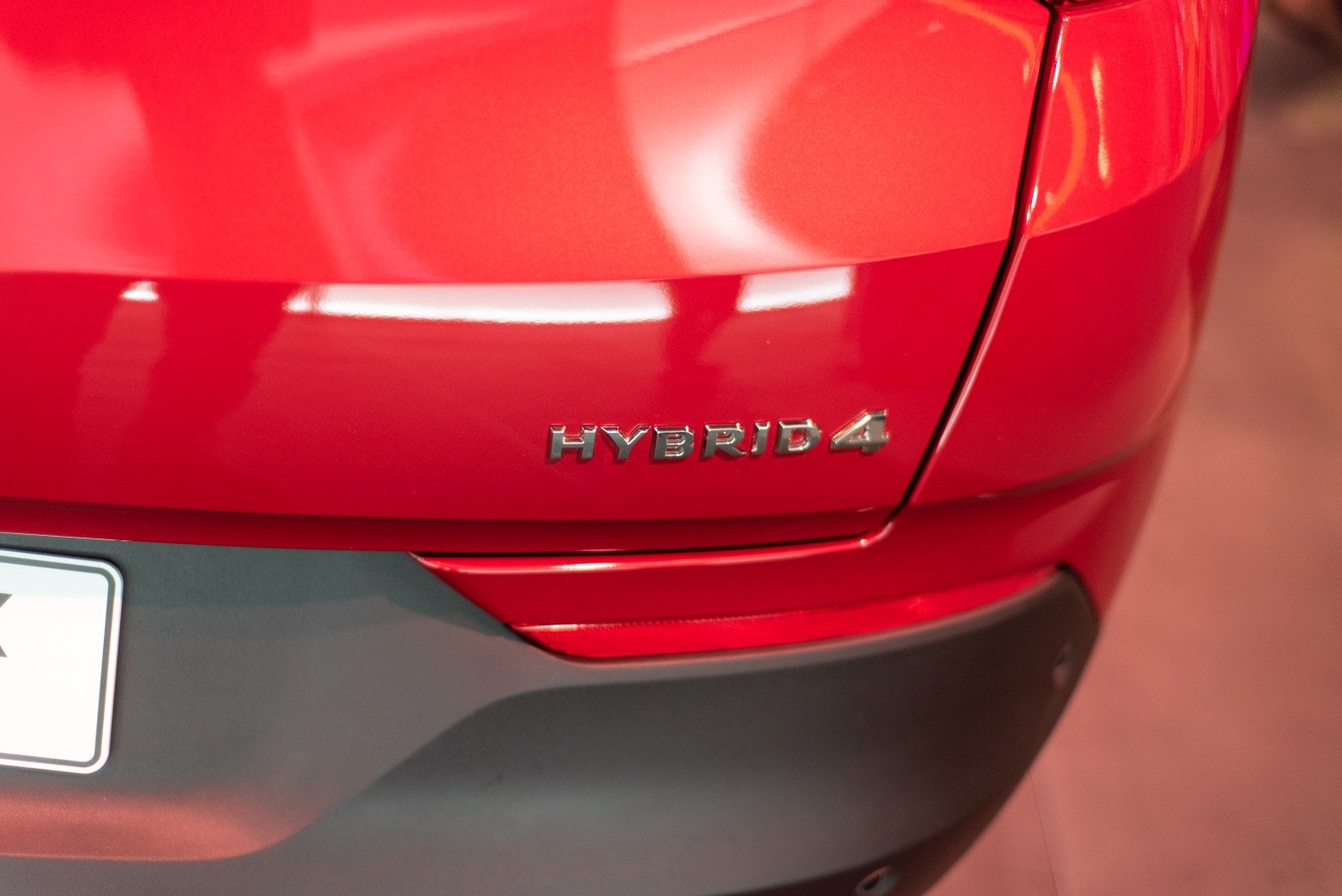 Close-up of Hybrid4 badge on red car rear panel