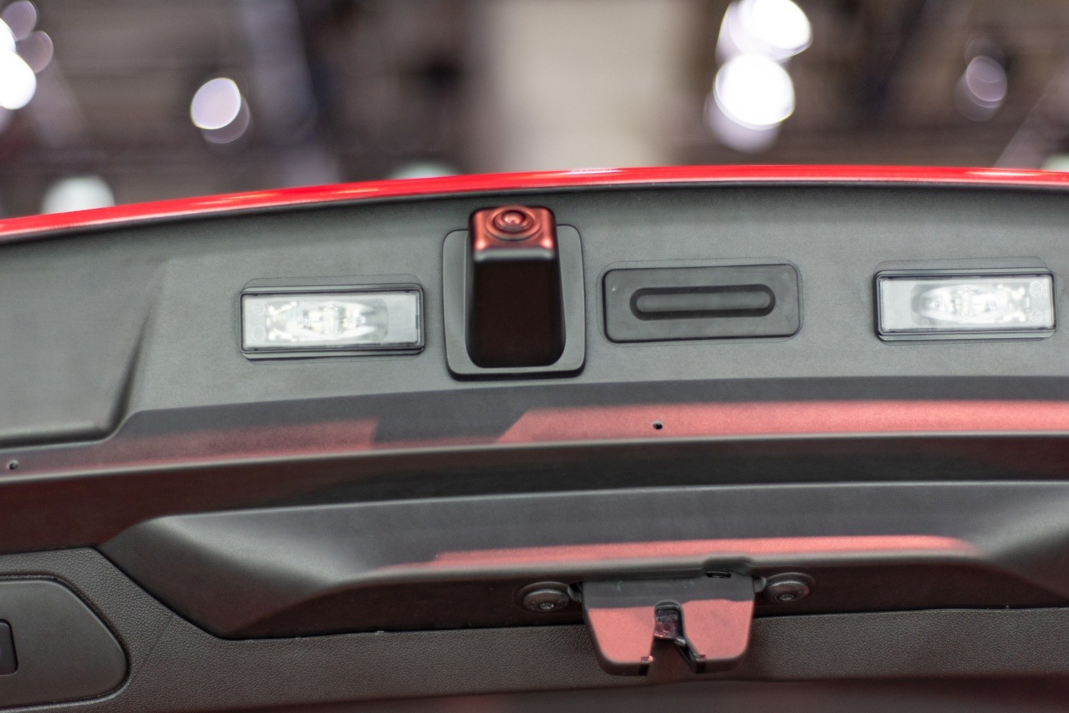 Rear trunk interior panel with rear view camera and light fixtures