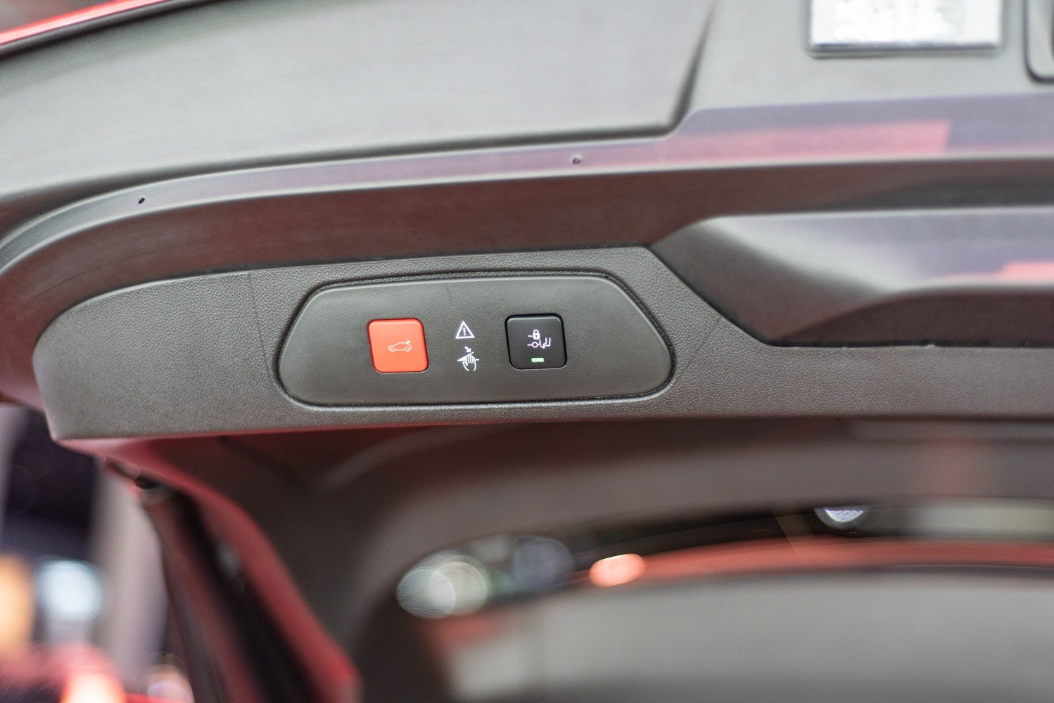 Close-up of tailgate control buttons with red and black push buttons