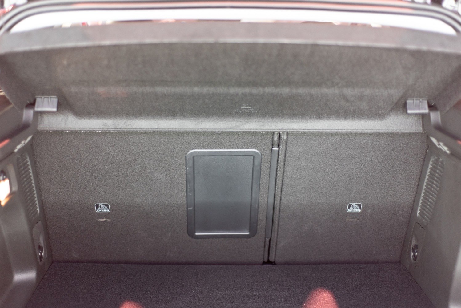 Rear seat split with central pass-through compartment in car trunk