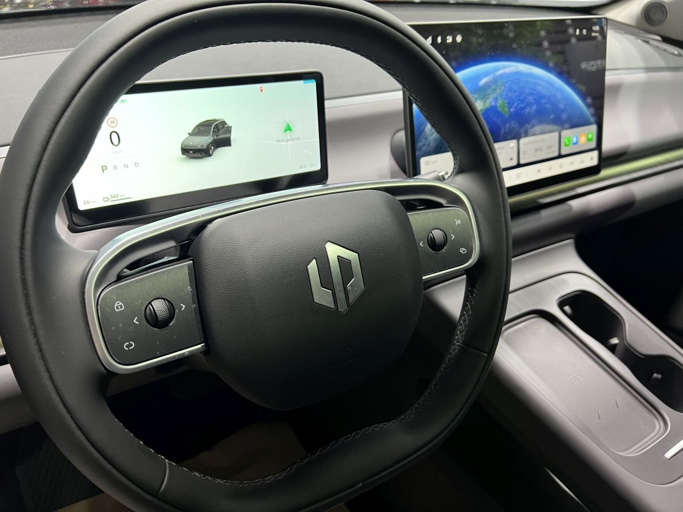Steering wheel with integrated controls and dual digital display screens inside a modern vehicle