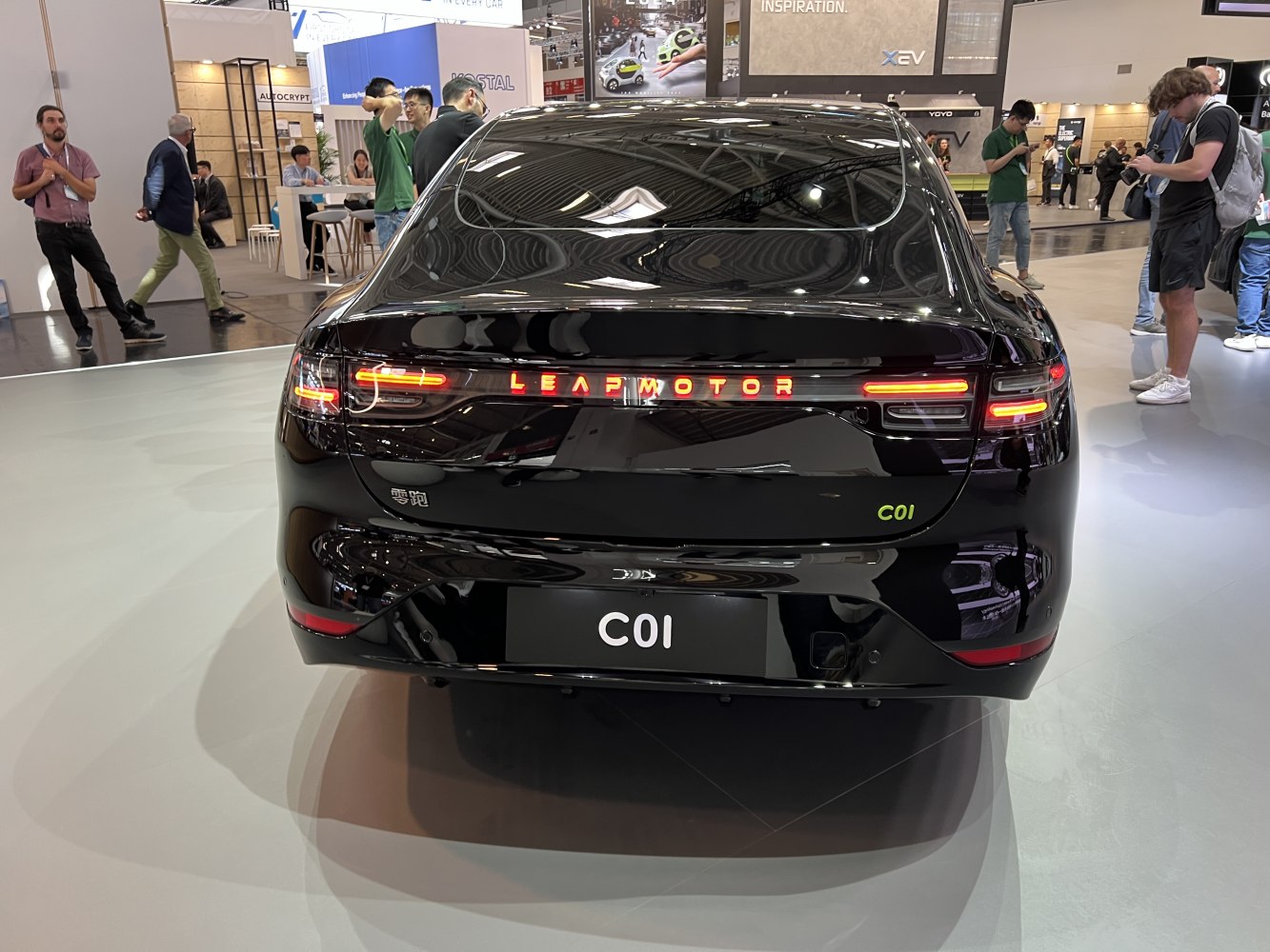 Rear view of black electric sedan with LED tail lights and illuminated branding