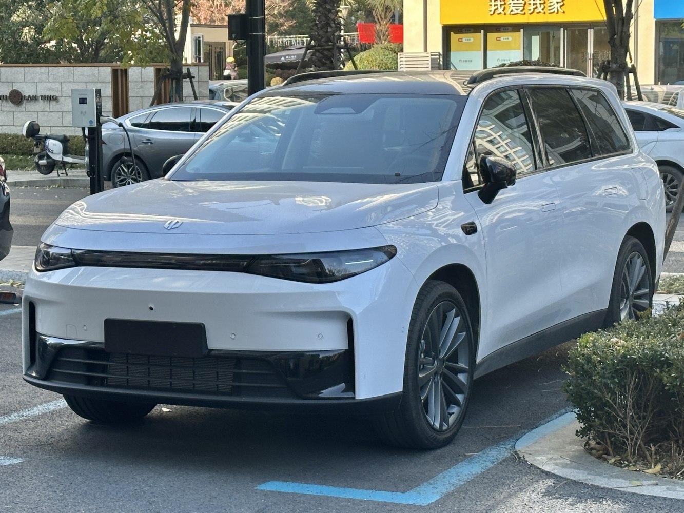 Sleek LED headlights and aerodynamic front design of a white electric SUV.
