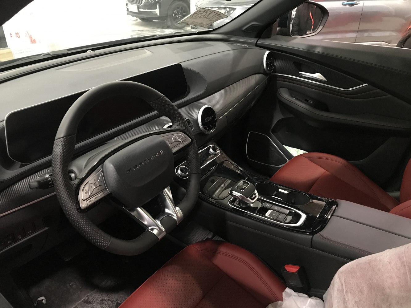 Modern digital dashboard and multifunction steering wheel with red leather seats.