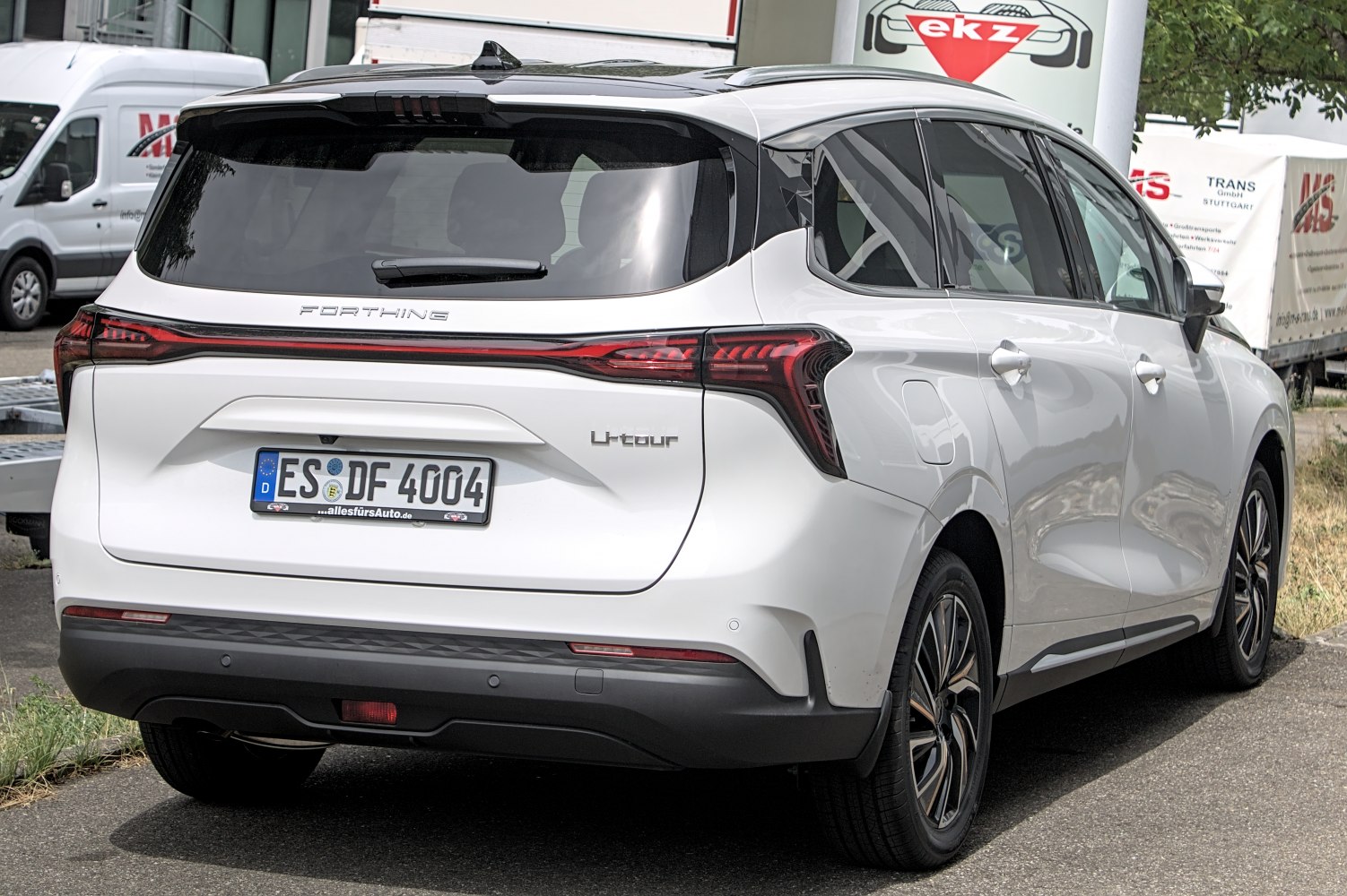 Rear view of white vehicle with sleek LED taillights and rear hatch.