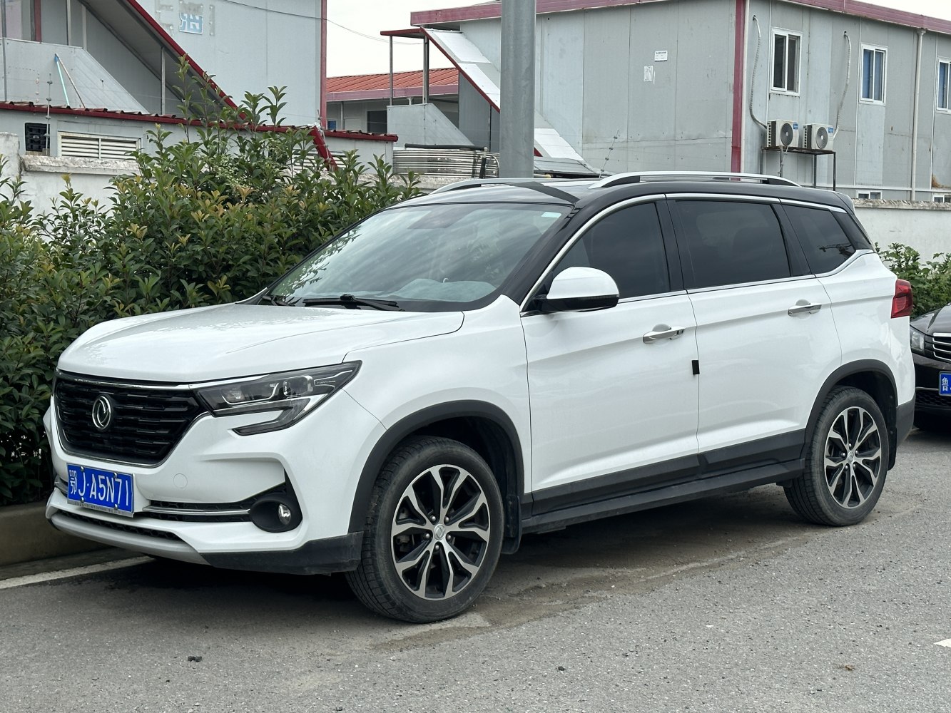 Front-side profile of a white SUV with distinctive grille and alloy wheels
