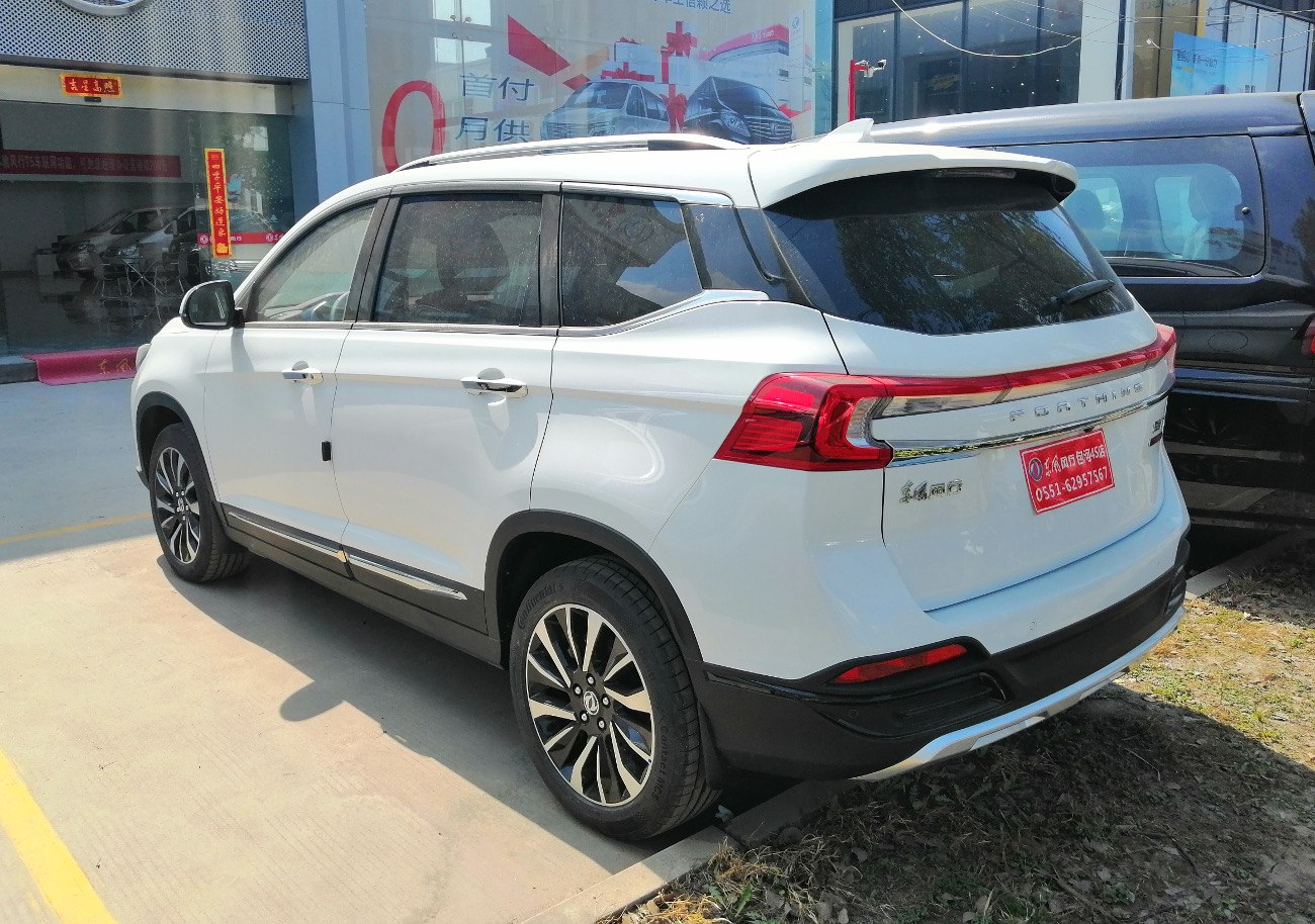 Rear side view of a modern white SUV with LED taillights and black trim