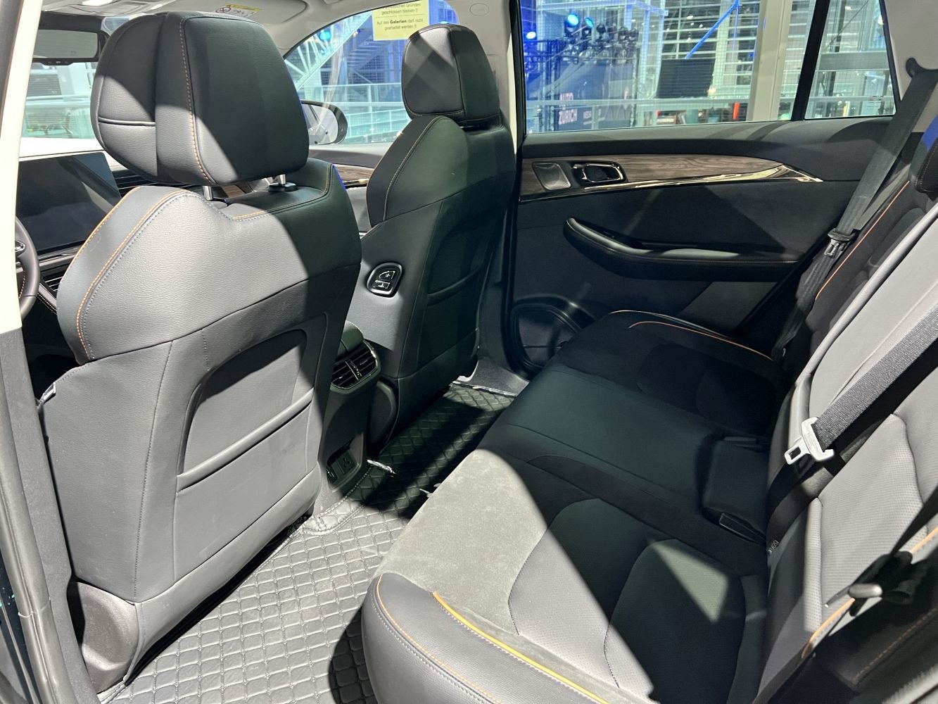 Rear seat interior with black leather upholstery and modern features