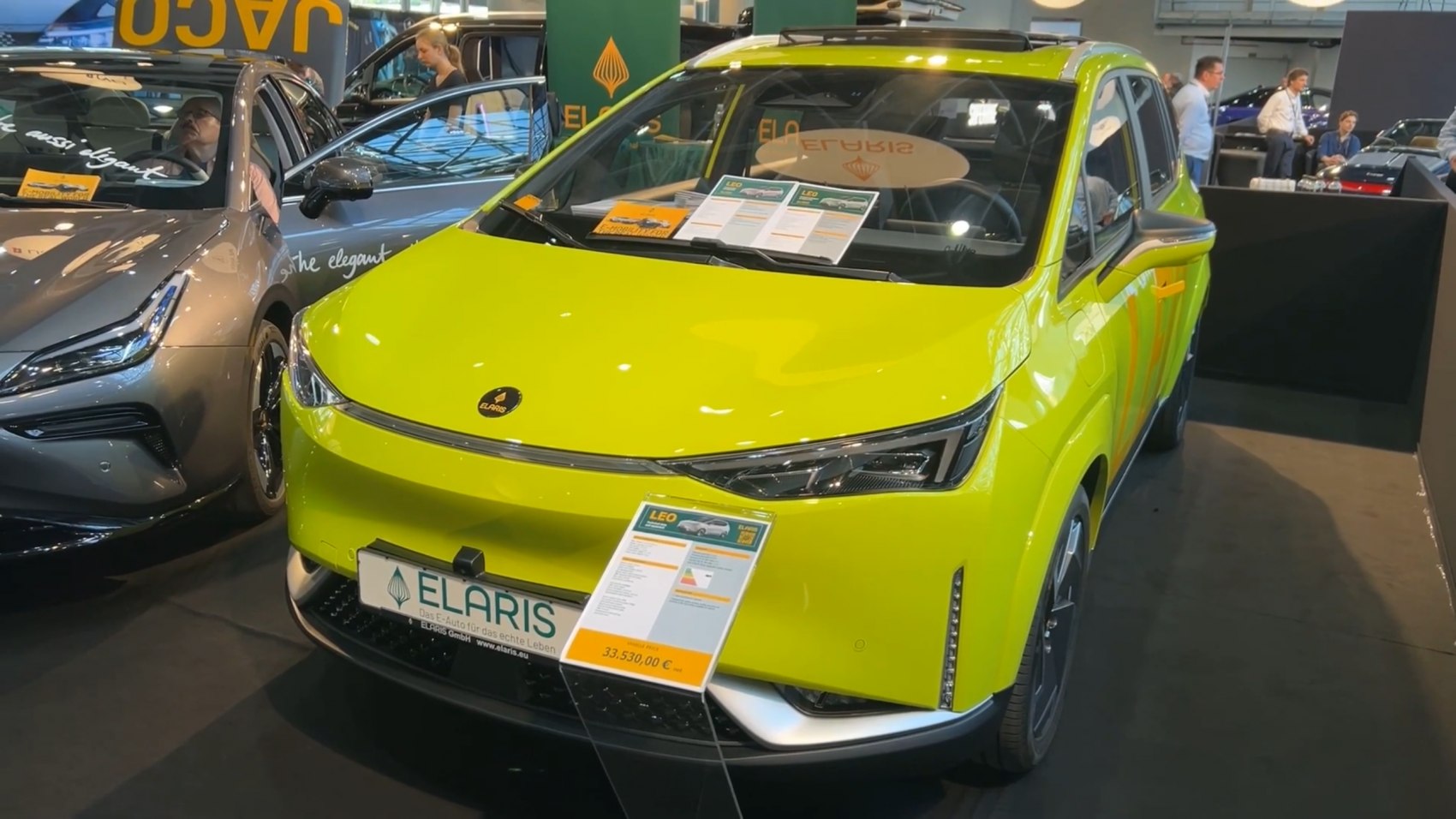 Front view of bright green electric car with sleek headlights and modern styling
