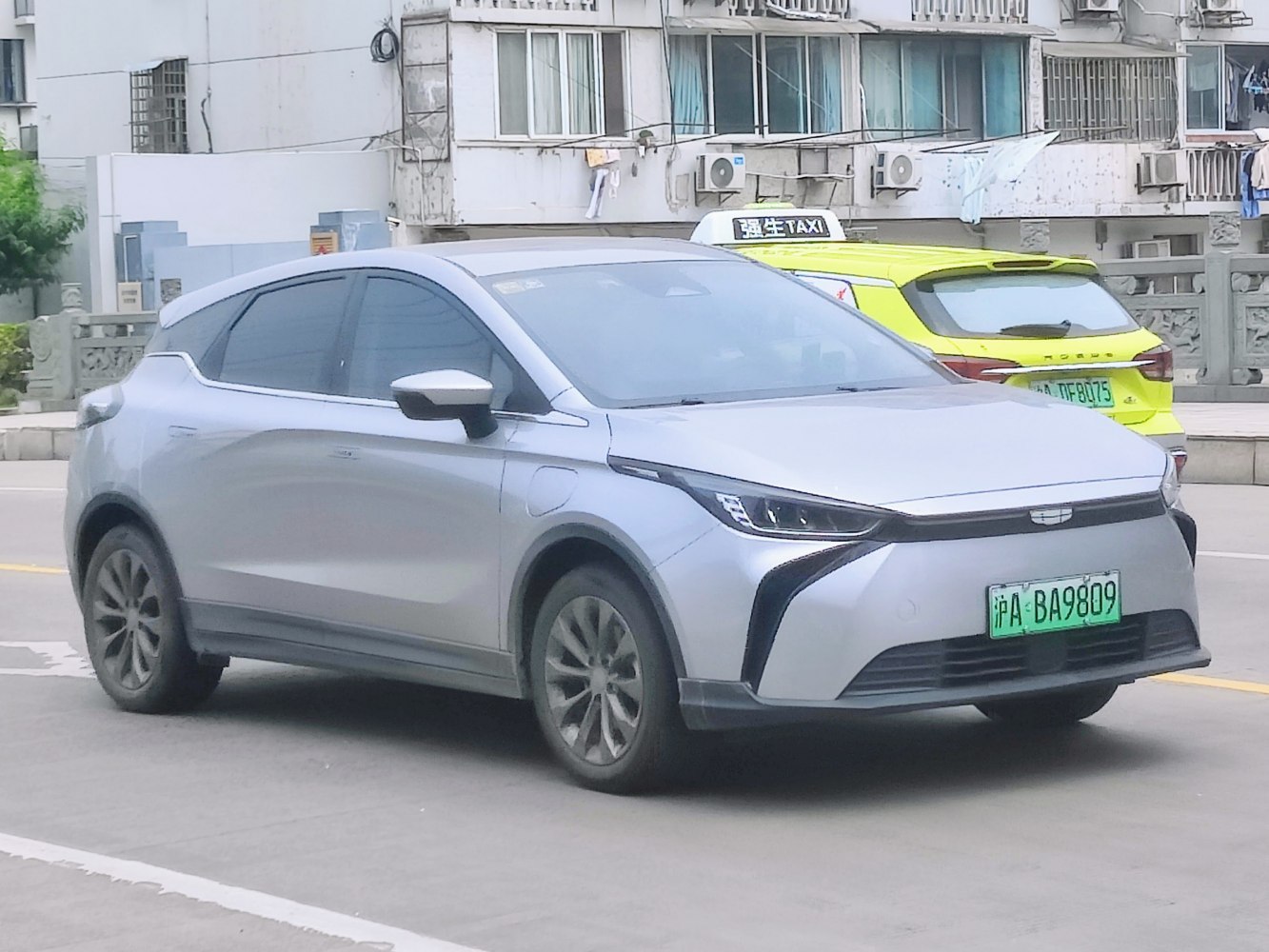 Sleek silver compact electric vehicle front side view with distinctive headlights