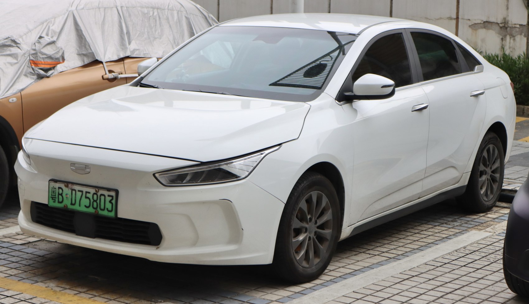 Aerodynamic front profile and modern headlights of white electric sedan