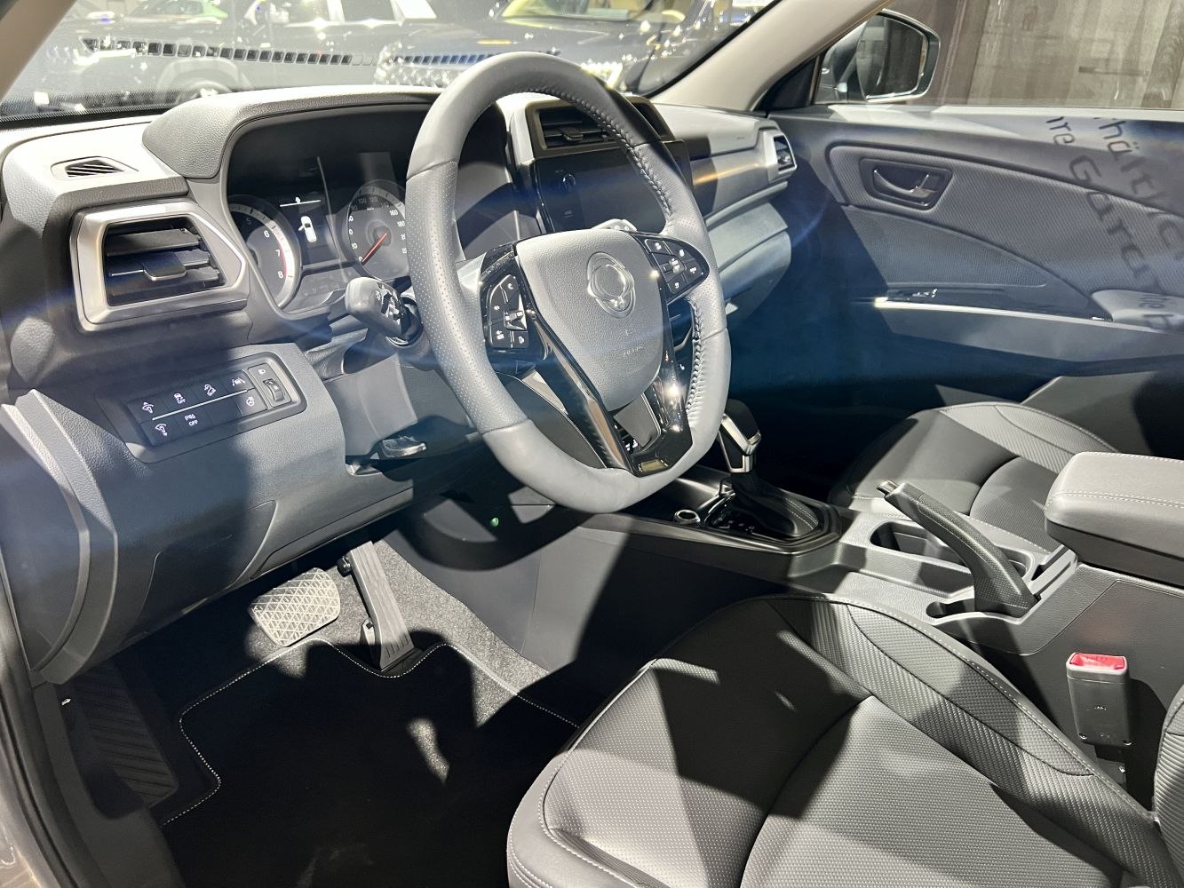 Steering wheel controls and dashboard interior with seats and gear shift