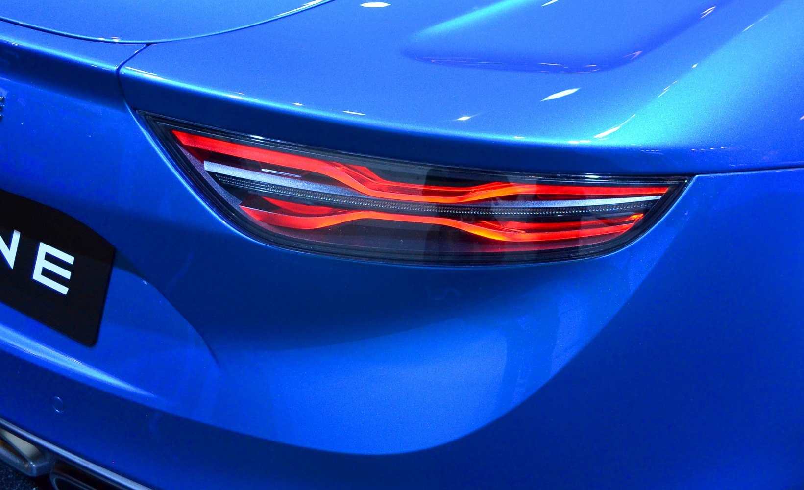 Close-up of a stylized rear LED tail light on a blue sports car