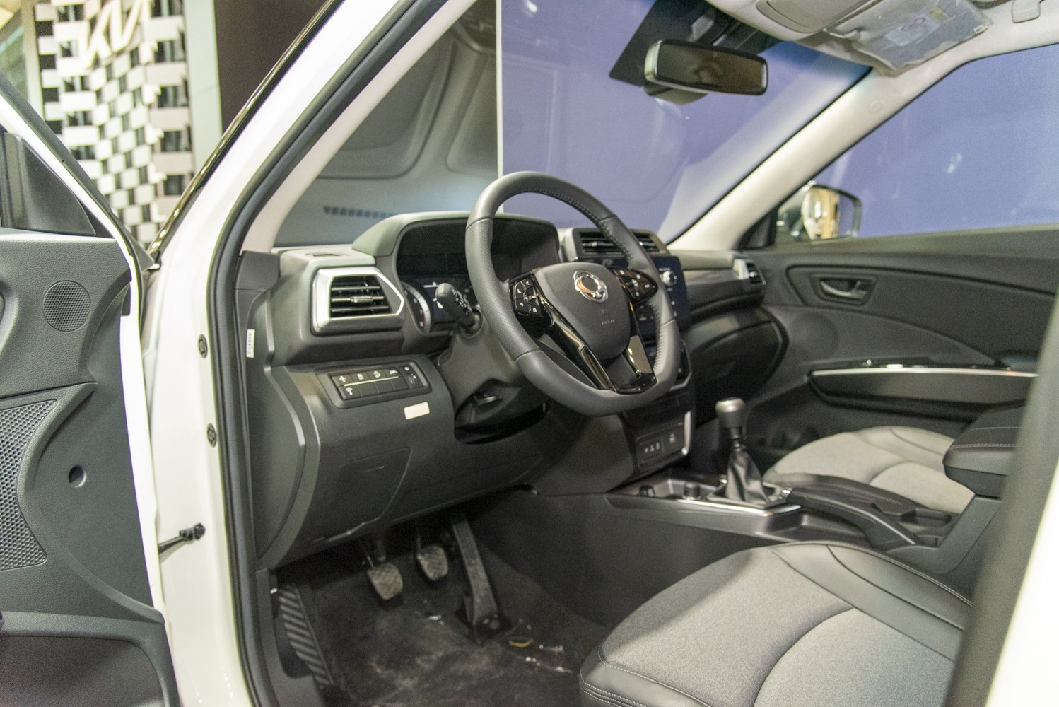 Car interior with dashboard, steering wheel, center console, and pedals
