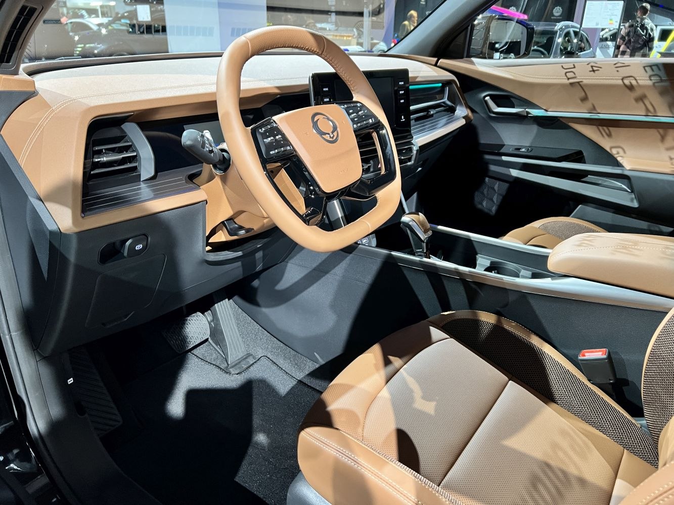 Modern steering wheel and dashboard with tan leather upholstery
