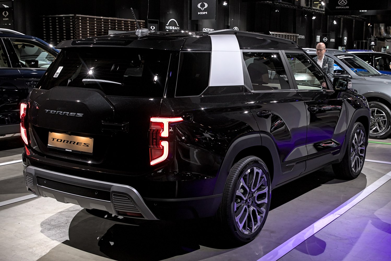 Rear and side view of a black modern SUV with LED taillights and multi-spoke wheels.