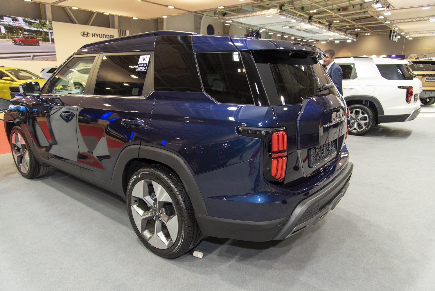 Rear view of an SUV with vertical taillights and alloy wheels indoors