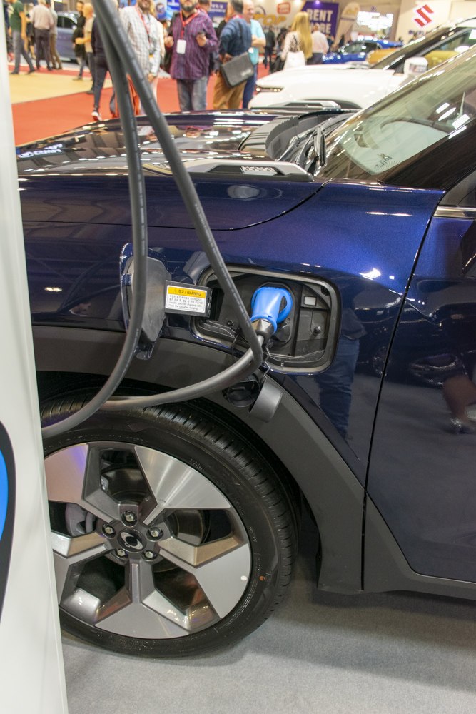 Close-up of electric vehicle charging port and alloy wheel design