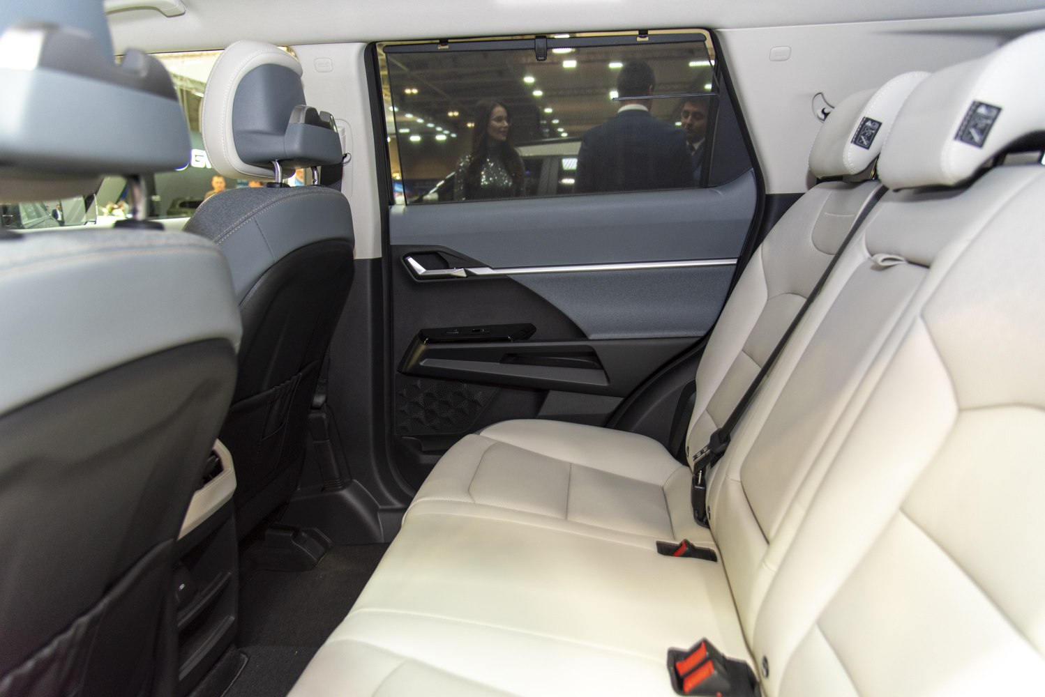 Rear passenger seats with white leather and door panel with controls