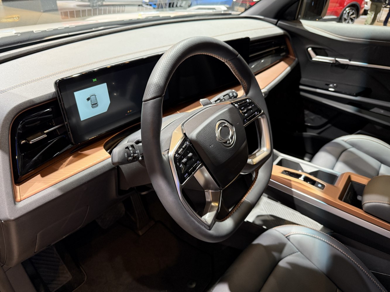 Steering wheel with integrated controls and wide digital dashboard display.