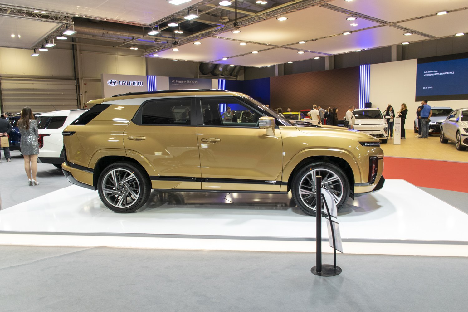 Side profile of a gold modern SUV with sleek design and alloy wheels.