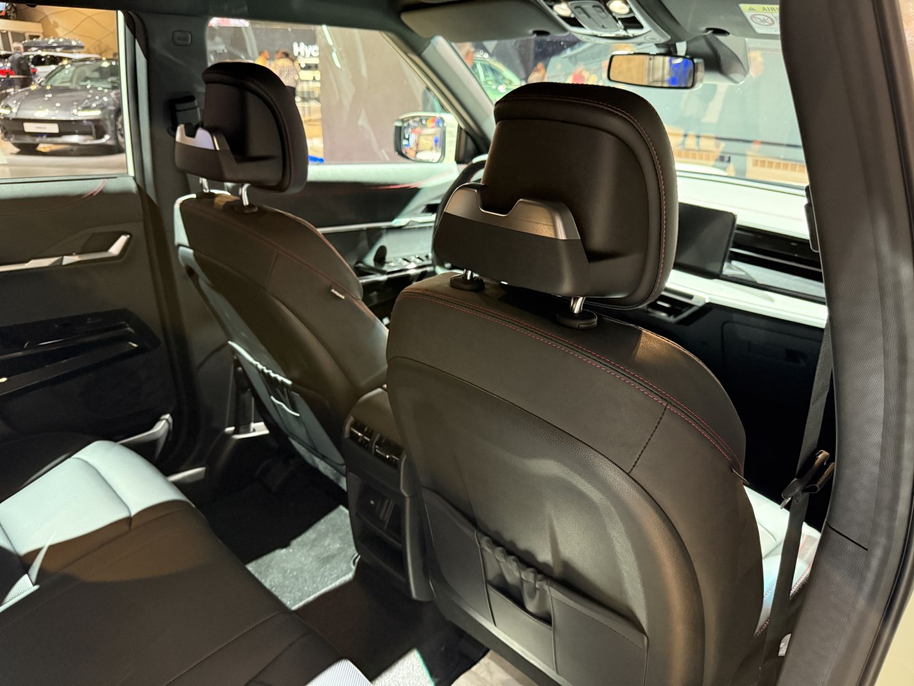 Rear seats and dashboard interior with black leather and red stitching