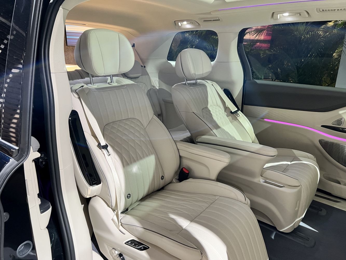 Beige leather rear seats with diamond stitching and ambient purple lighting in SUV interior