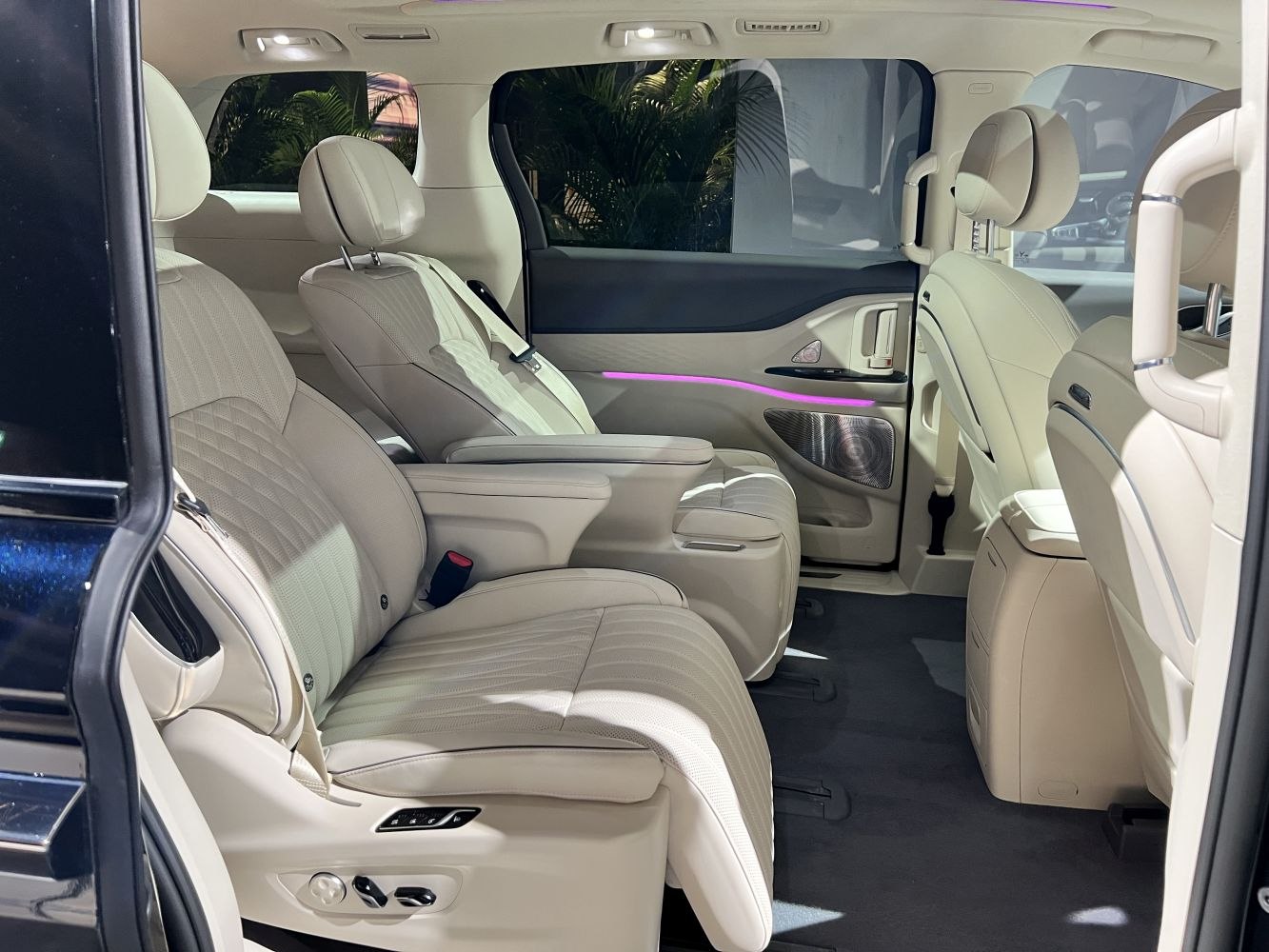 Luxury beige leather seats with advanced controls and purple ambient lighting