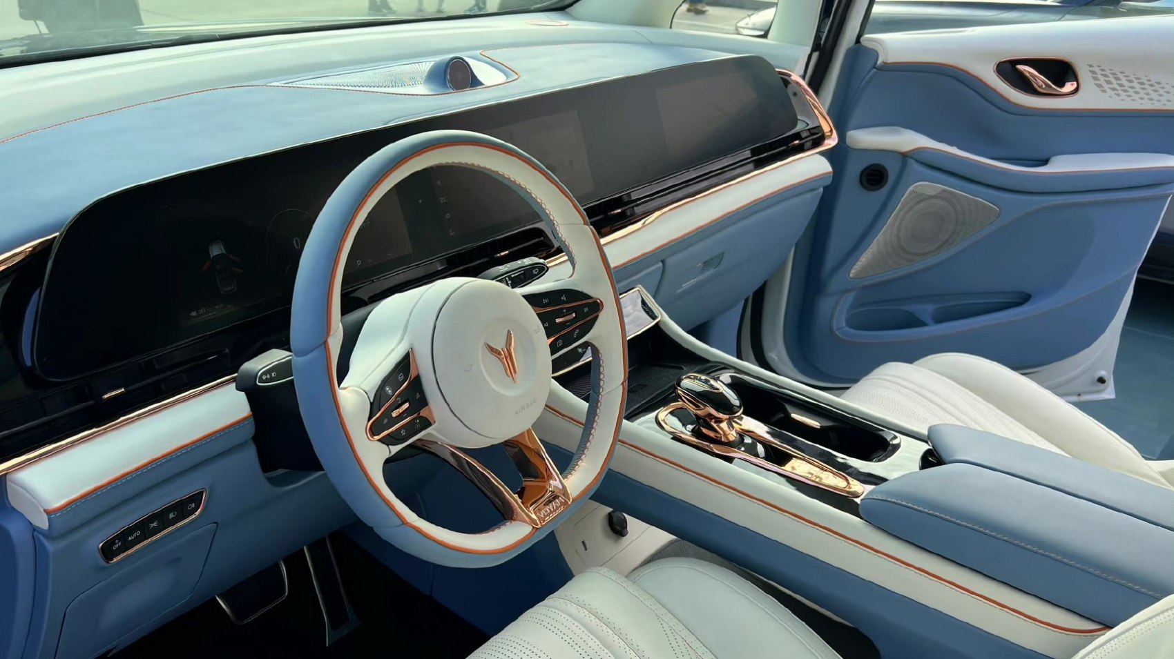 Two-tone blue and white steering wheel with modern dashboard and center console