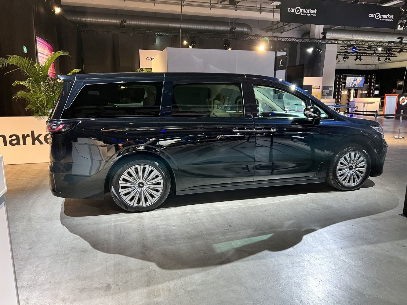 Modern black minivan side view with rear spoiler and alloy wheels