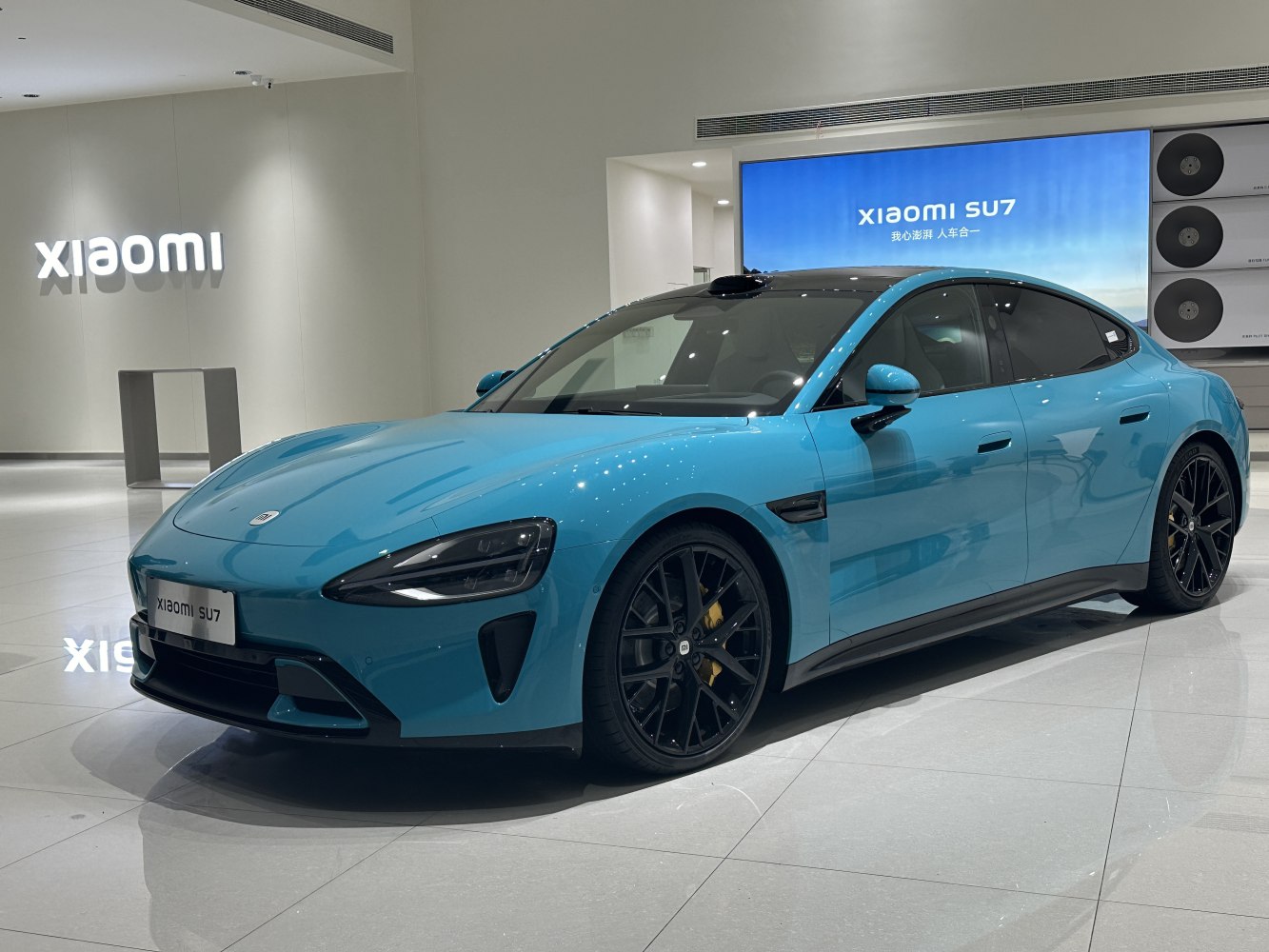 Aerodynamic blue electric sedan with black alloy wheels.