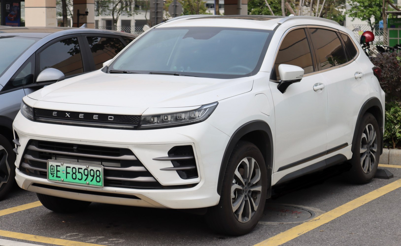 Front side view of white SUV with LED headlights and horizontal grille