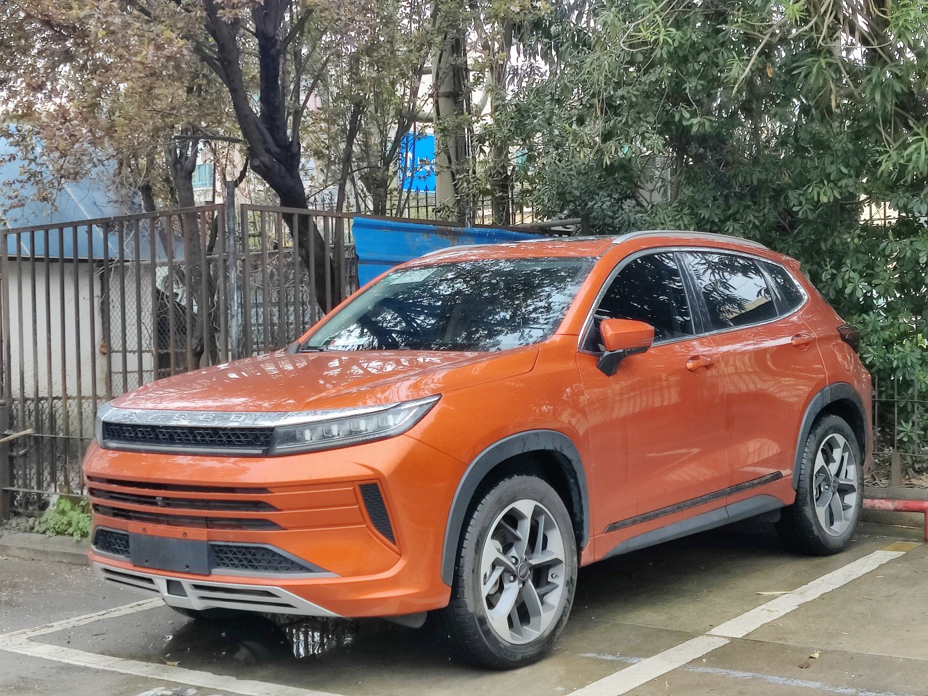 Orange SUV with slim LED headlights and sporty alloy wheels