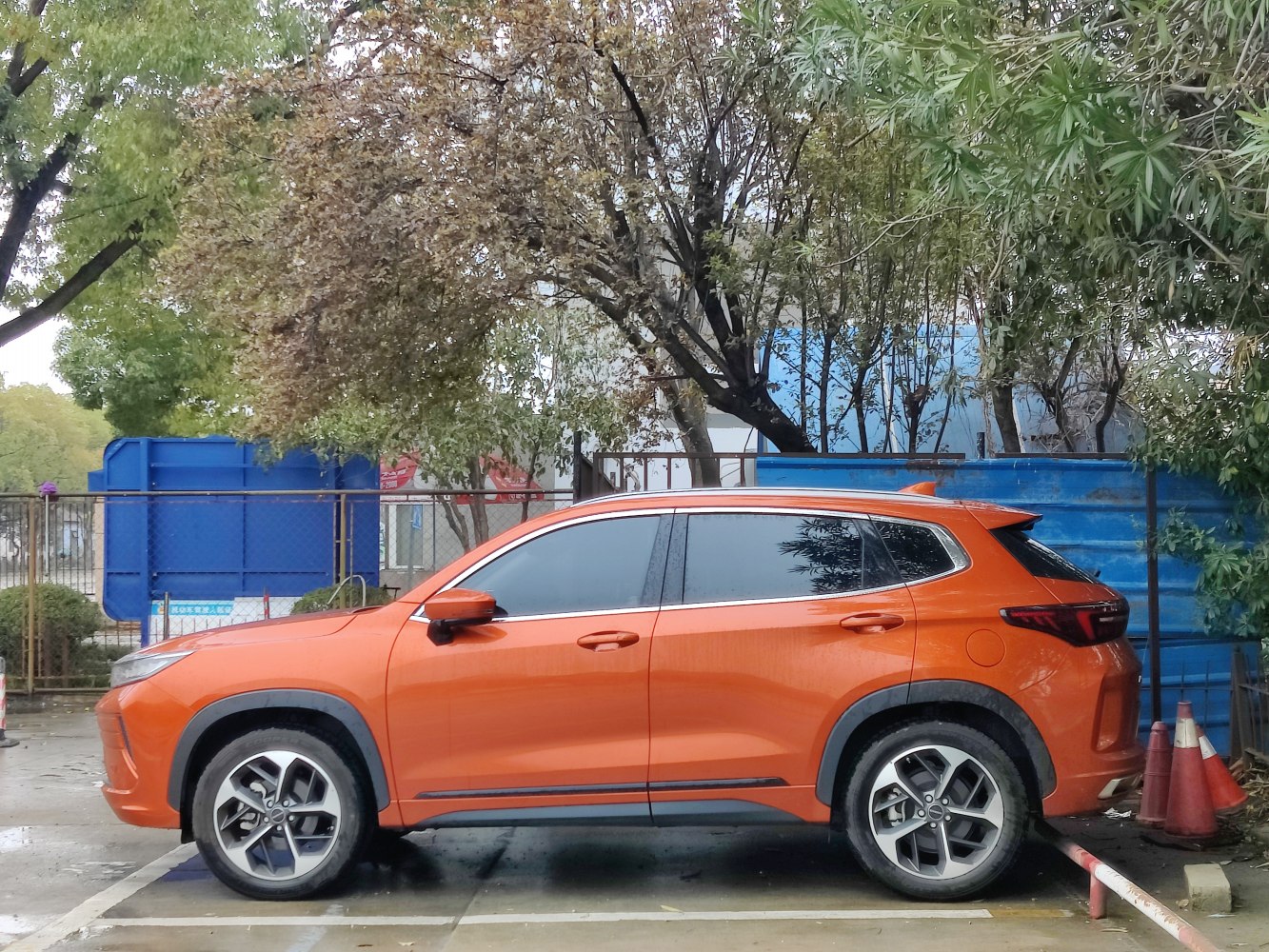 Orange SUV side profile with alloy wheels and black window trim