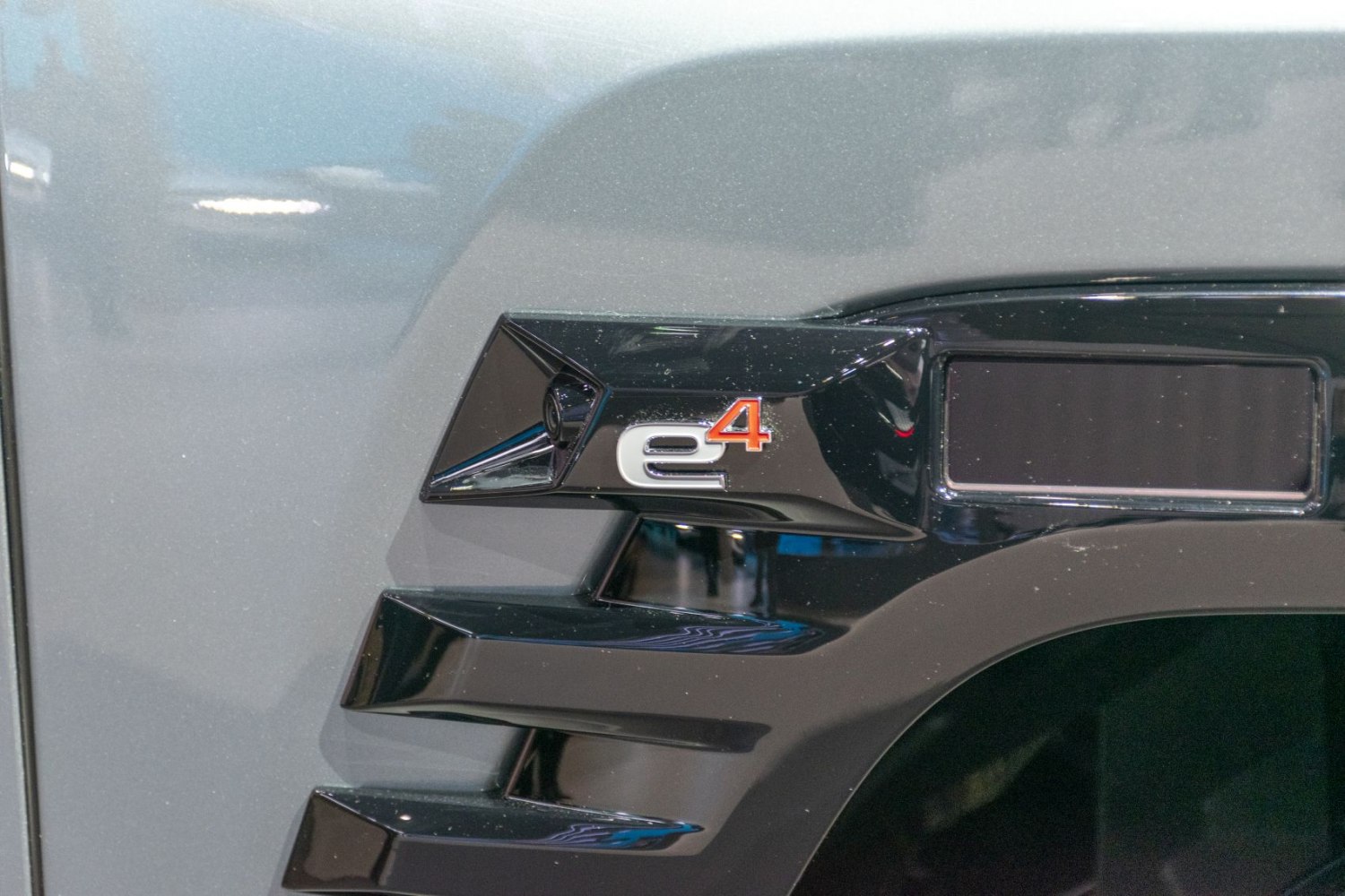Close-up of e4 badge and glossy black fender vents on vehicle side