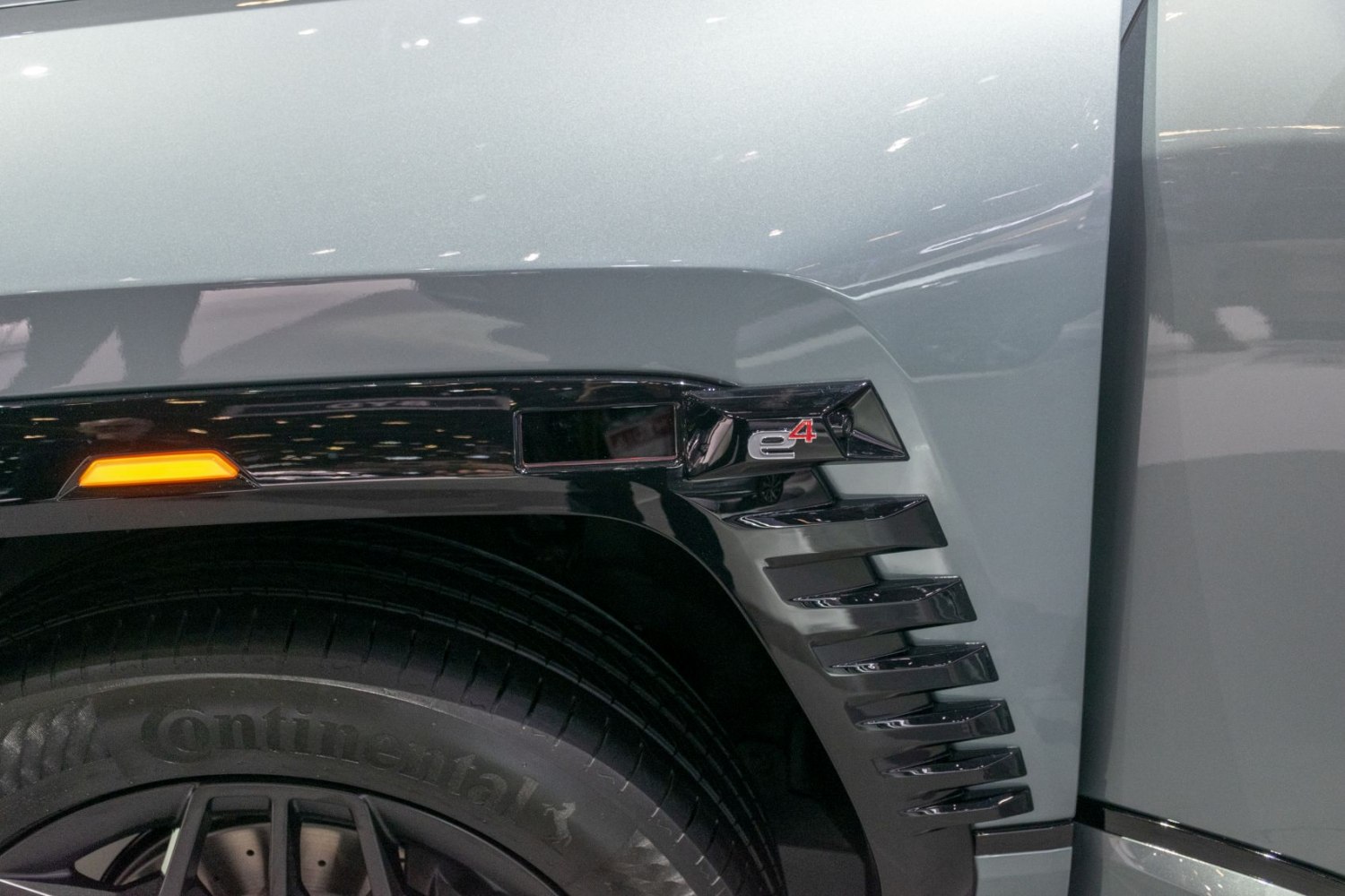 Close-up of e4 badge and Continental tire on SUV fender with orange side marker