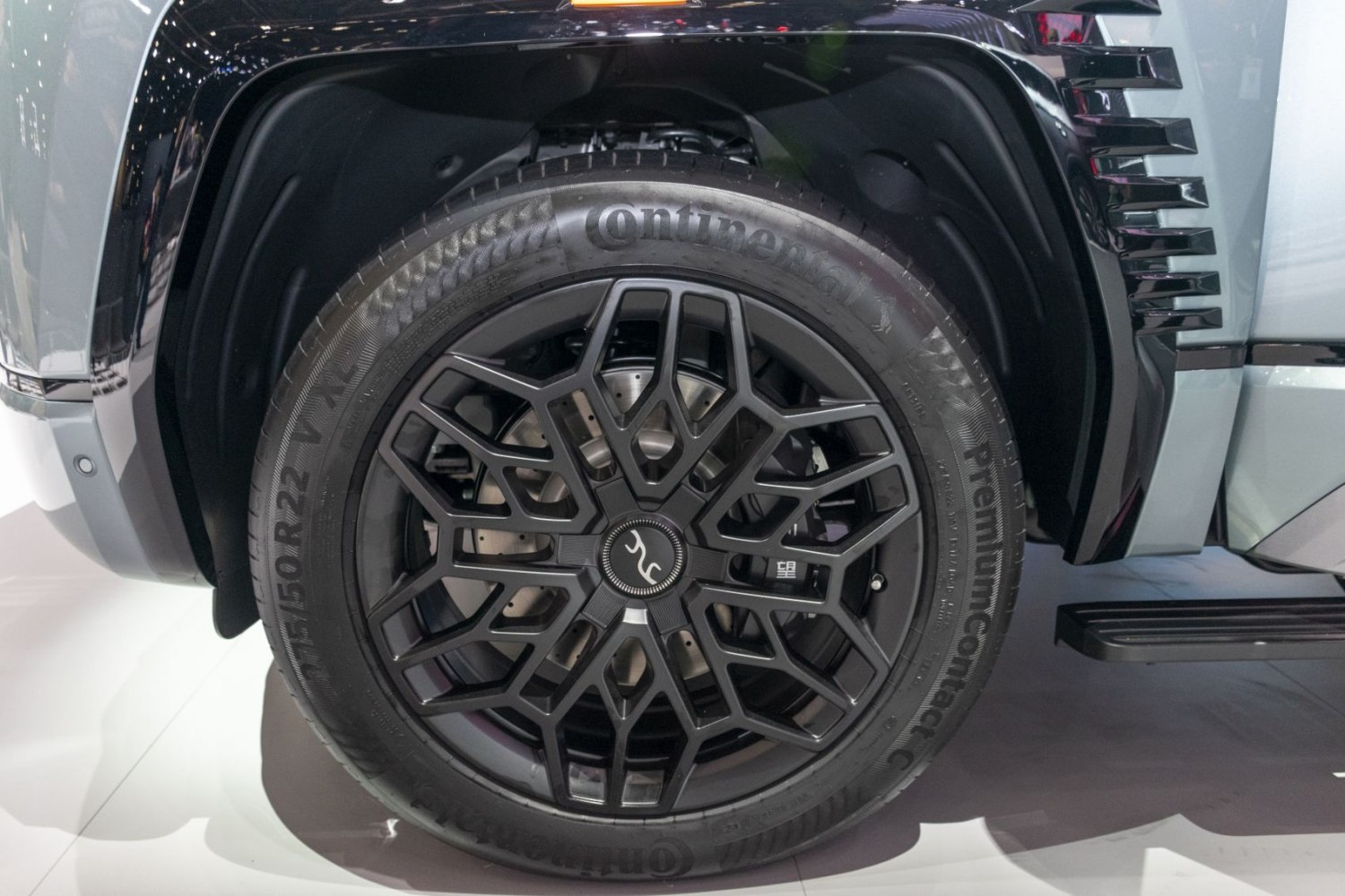 Complex black alloy wheel with Continental tire in a wheel arch