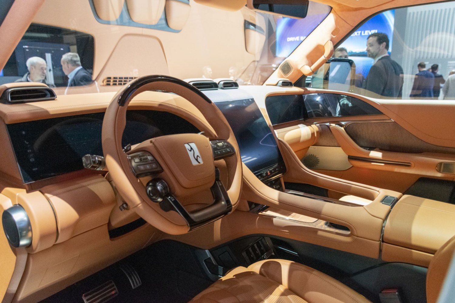 Luxury tan leather interior with dual digital displays and unique steering wheel.