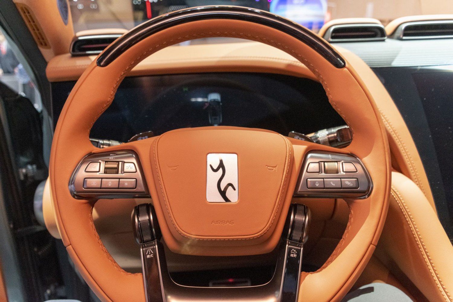 Luxury steering wheel with control buttons and premium leather upholstery
