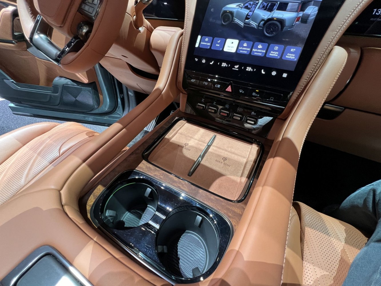 Central console with wireless charging pads and touchscreen.