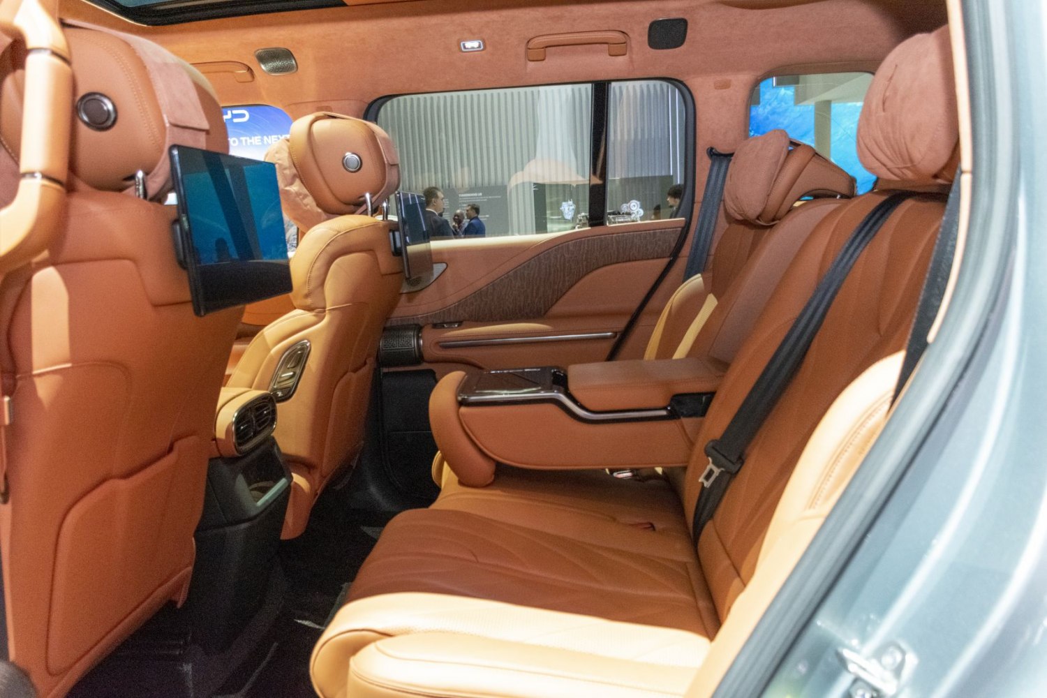 Tan leather rear seats with entertainment screens and spacious legroom