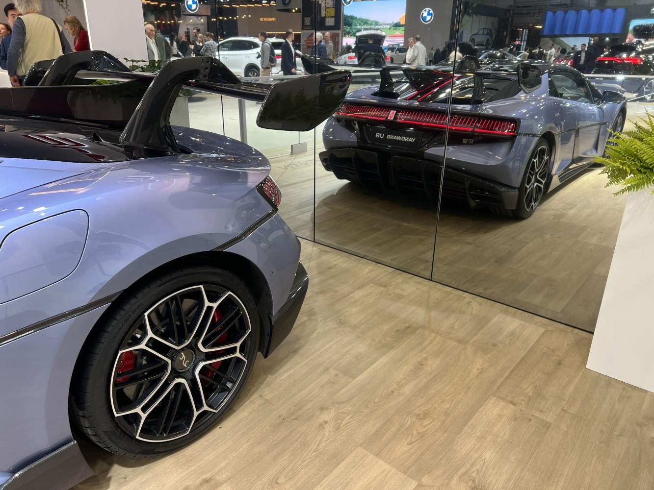 Rear aerodynamic carbon spoiler and multi-spoke alloy wheel with red brake calipers.