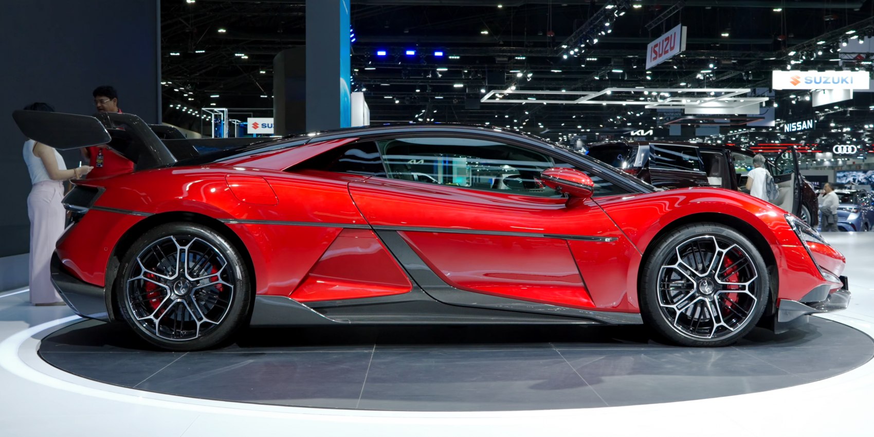 Aerodynamic red sports coupe with carbon fiber rear wing and sport rims