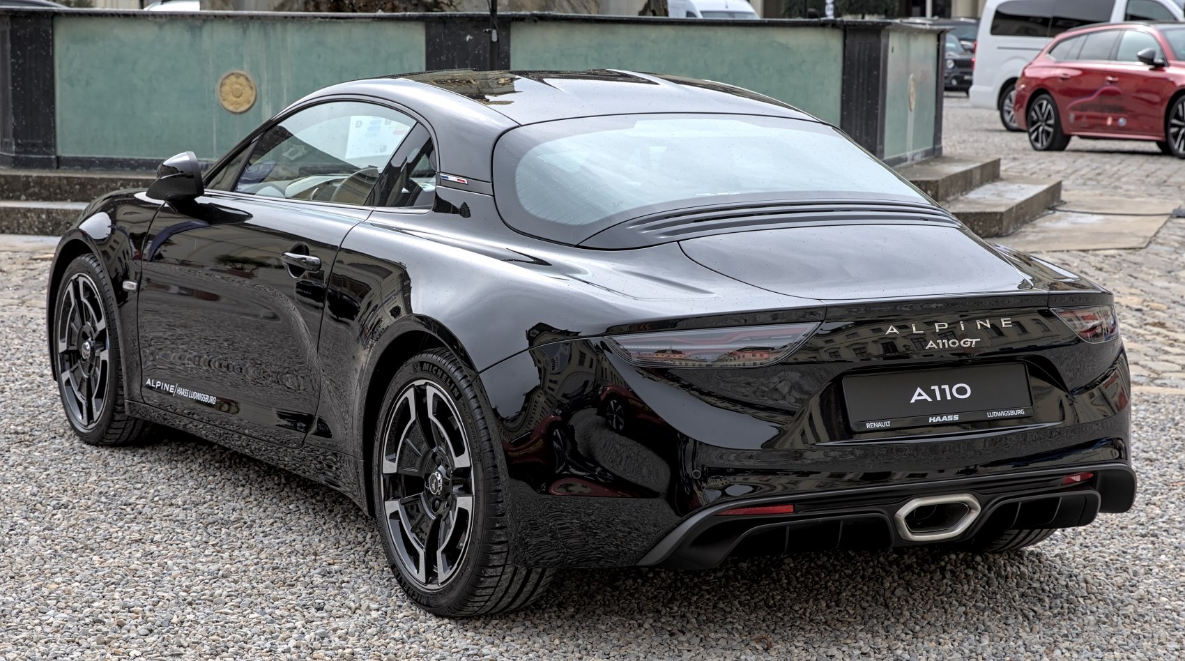Rear view of black sports coupe with central exhaust and sleek taillights