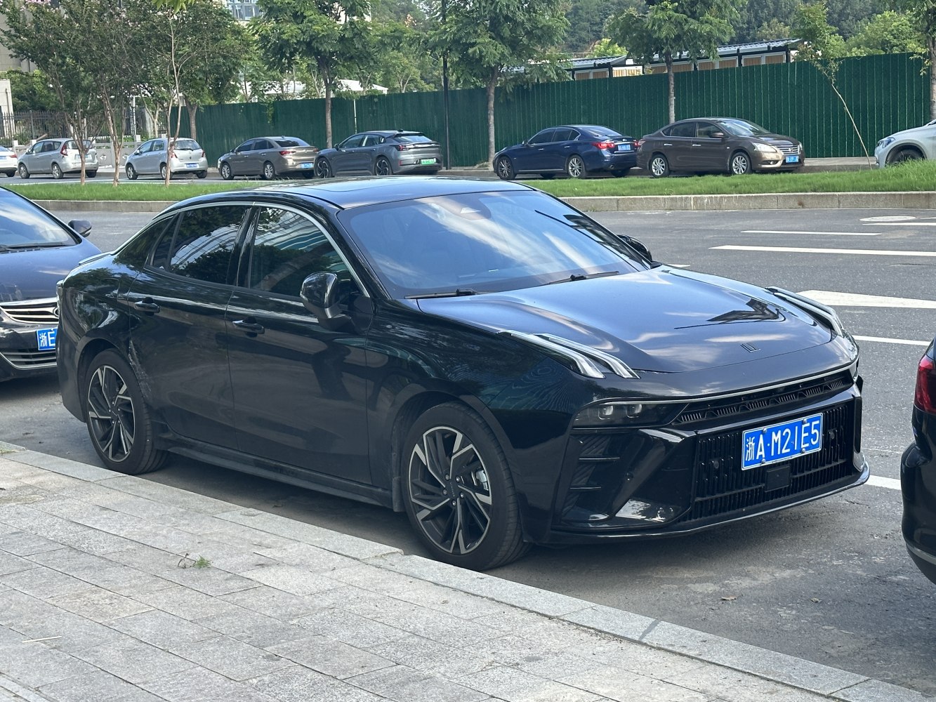 Sleek black modern sedan with split LED headlights and aggressive front grille